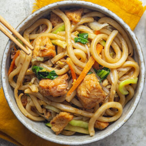 Stir-Fried Yaki Udon Noodles, mixed vegetables, topped with wild-caught savory teriyaki salmon