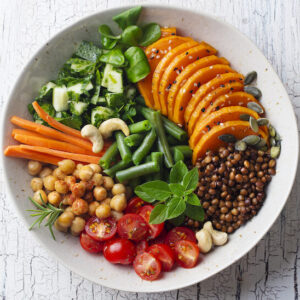 Healthy vegetarian salad. Lentil, chickpea, carrot, pumpkin seeds, tomatoes, cucumber, greens, mung beans, slices sweet potatoes, green beans. Served with cashew chipotle sauce.